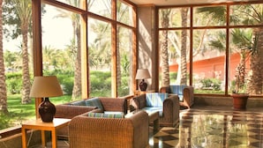 A spacious lobby with large windows, wicker furniture, and a checkered floor. - Kefi Palmera Beach Resort El Sokhna - Family Only (Ataqah)