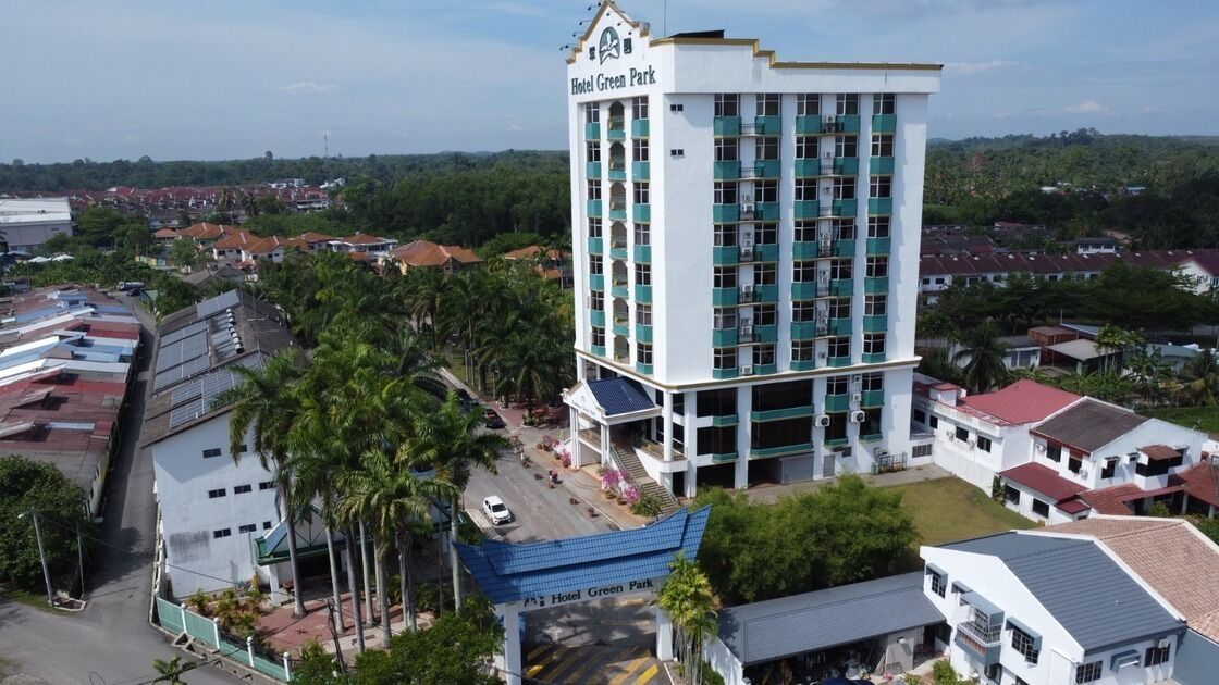A multi-story hotel with a prominent sign reading "Hotel Green Park."