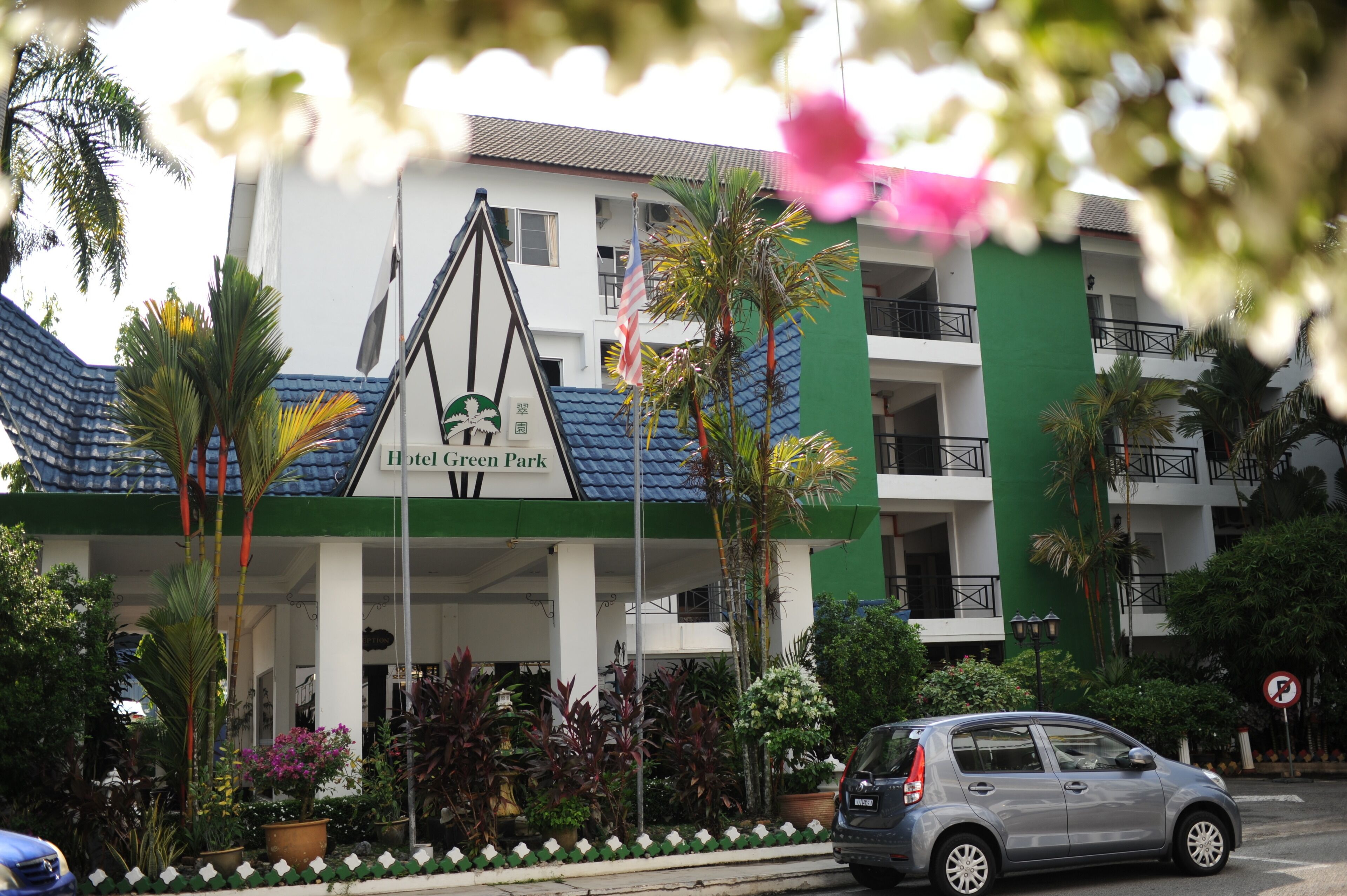 Hotel Green Park with a green and white facade, a blue roof, and a signboard.