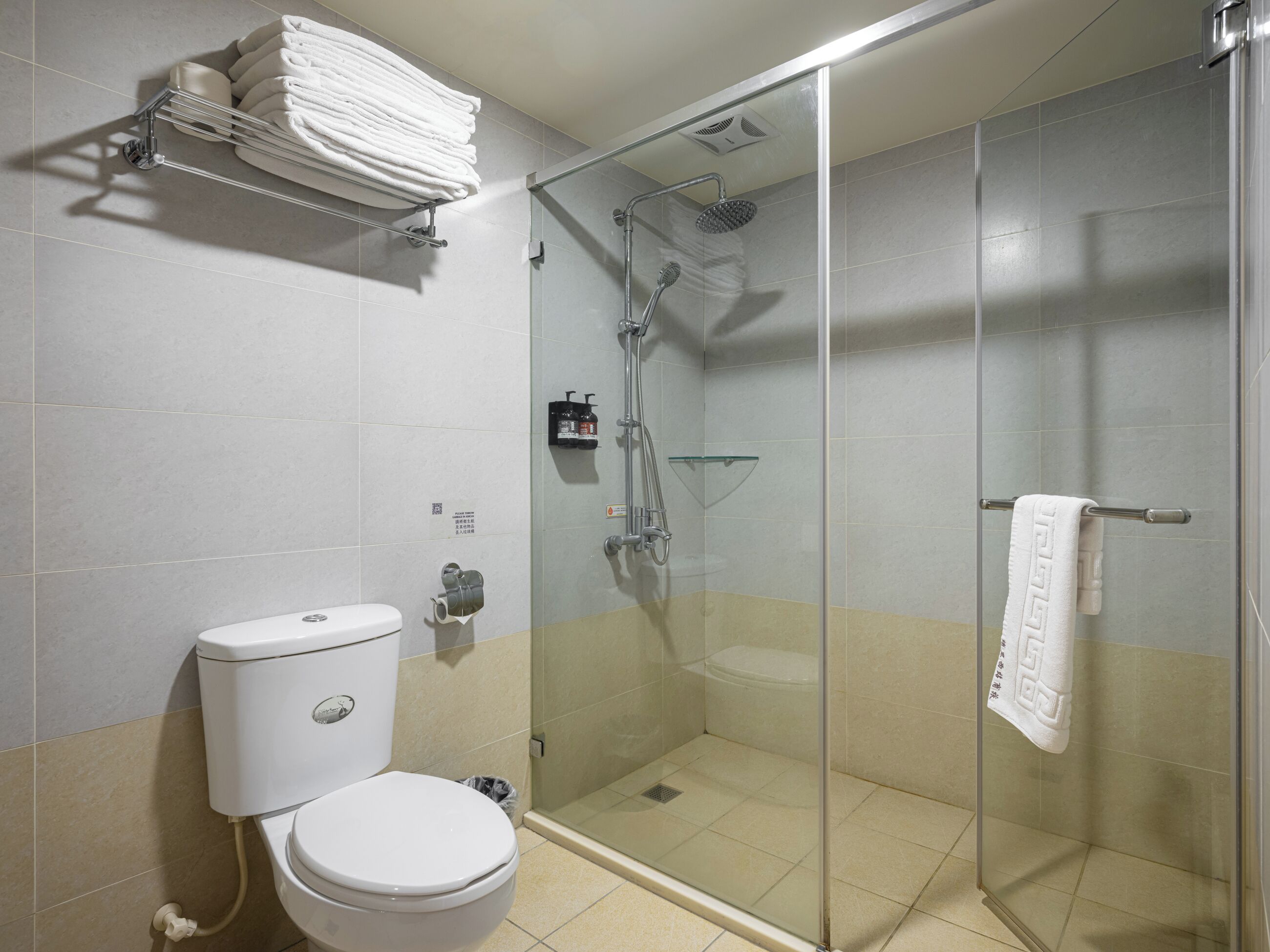 Ein modernes Badezimmer mit einer Duschkabine, einer Toilette und einem Handtuchhalter.