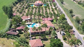 An aerial view of a resort with multiple buildings, a swimming pool, and well-maintained gardens. - Grenadine Lodge (Ortaca)