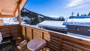 Eine Holterrasse mit Blick auf eine verschneite Berglandschaft.