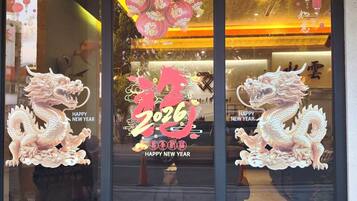 Une devanture de magasin décorée pour les fêtes du Nouvel An, avec notamment deux statues de dragons et une grande lanterne rouge.