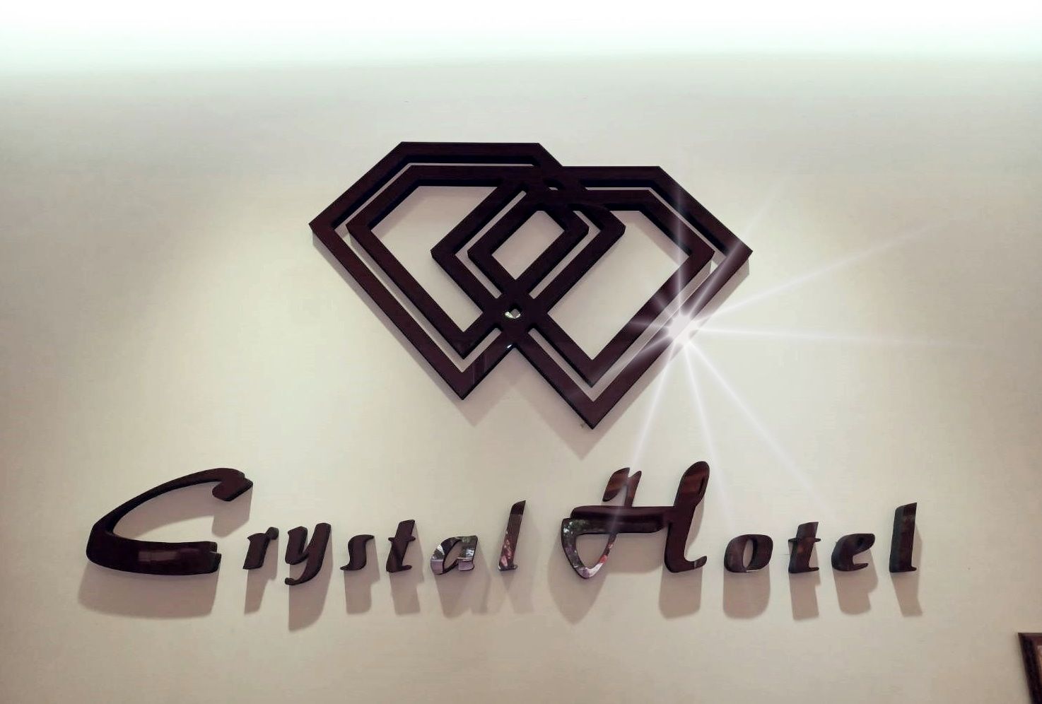 A logo and name of Crystal Hotel on a wall.