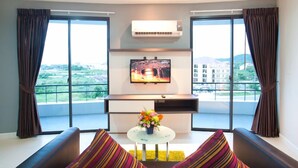 Una sala de estar moderna con un televisor de pantalla plana, una mesa de centro con flores y un sofá.