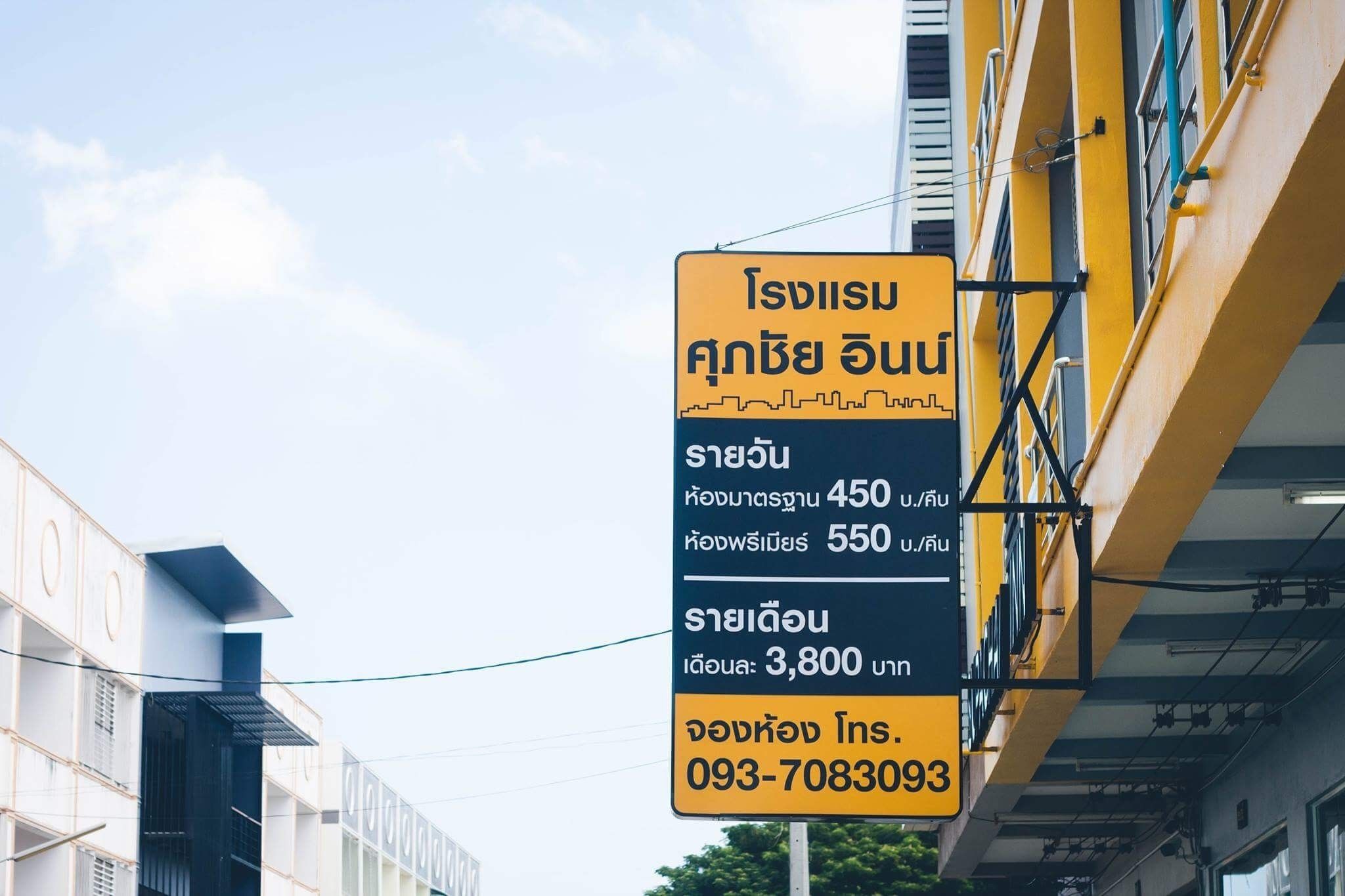 A hotel sign with Thai text, indicating room numbers 450 and 550, and a price of 3,800 baht per night.