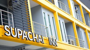 Segnaletica di un hotel con la scritta 'SUPACHAL INN'.