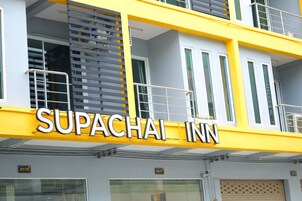 A building with the sign 'SUPACHAI INN' indicating a hotel.