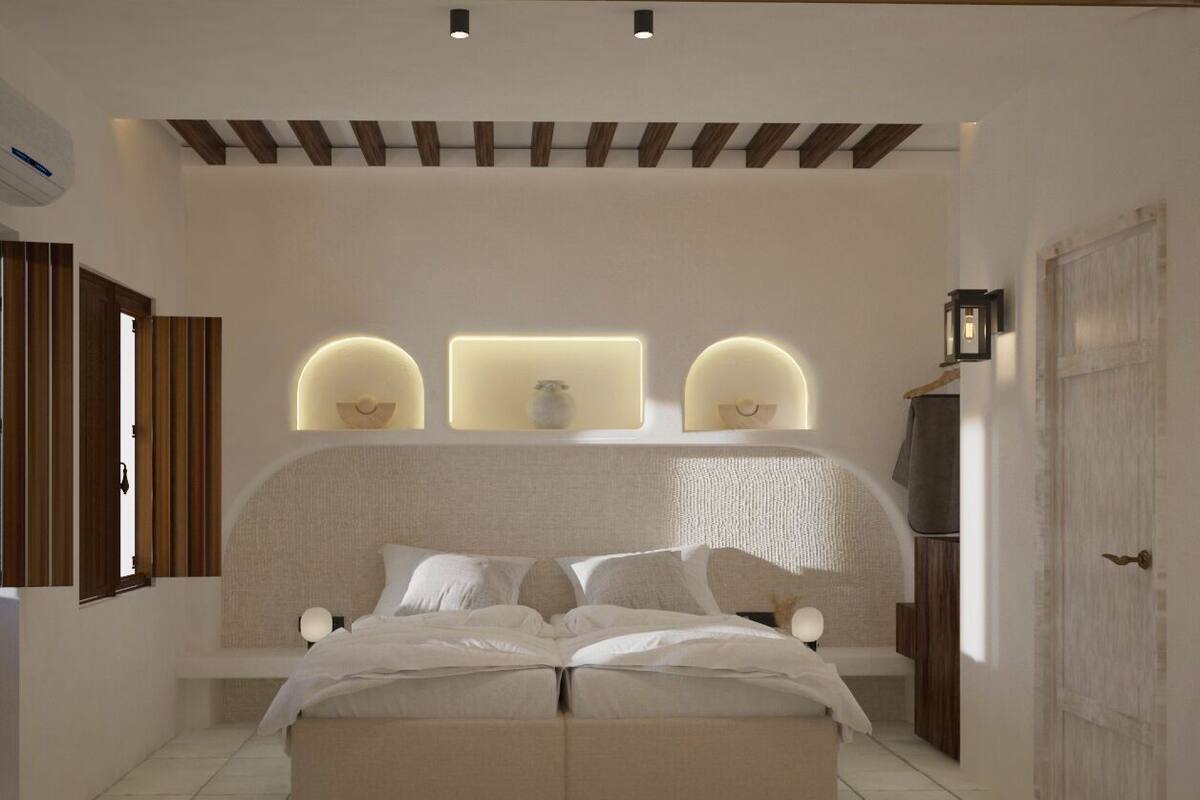Ein Schlafzimmer mit einem großen Bett, einem Kopfteil mit integrierter Beleuchtung, einem Nachttisch und einem Kleiderschrank.