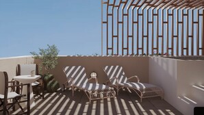 Zona d'estar a l'aire lliure amb sol, taula i cadires, una pérgola de fusta i vista al cel.
