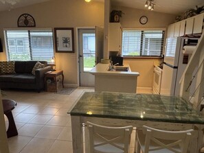 A compact living space with a kitchenette, a dining area, and a sofa. - Seaside S 4302 1 Bedroom Condo by RedAwning (New Smyrna Beach)