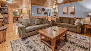 A cozy living room with wooden furniture, a coffee table, and a rug. - The Ranch Cabin on 6 Secluded Acres in the Great Smoky Mountains by RedAwning (Sevierville)
