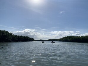 A calm river with kayaks, surrounded by dense trees and a clear sky. - Coconut Palms Townhome 2 Bedroom Townhouse by RedAwning (New Smyrna Beach)