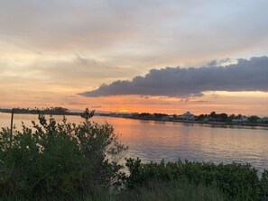 A sunset over a calm lake with a distant shoreline. - Coconut Palms Townhome 2 Bedroom Townhouse by RedAwning (New Smyrna Beach)