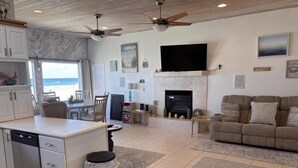 A spacious living area with a kitchen, a fireplace, a sofa, and a television.