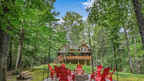 Een chalet met een terras, omringd door een bos.