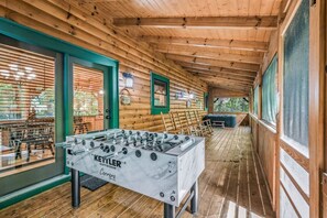 Ein Innenbereich mit Holzboden, einem Tischfußballtisch mit der Aufschrift 'KEYTIER OUTDOOR' und Blick ins Freie durch große Fenster.