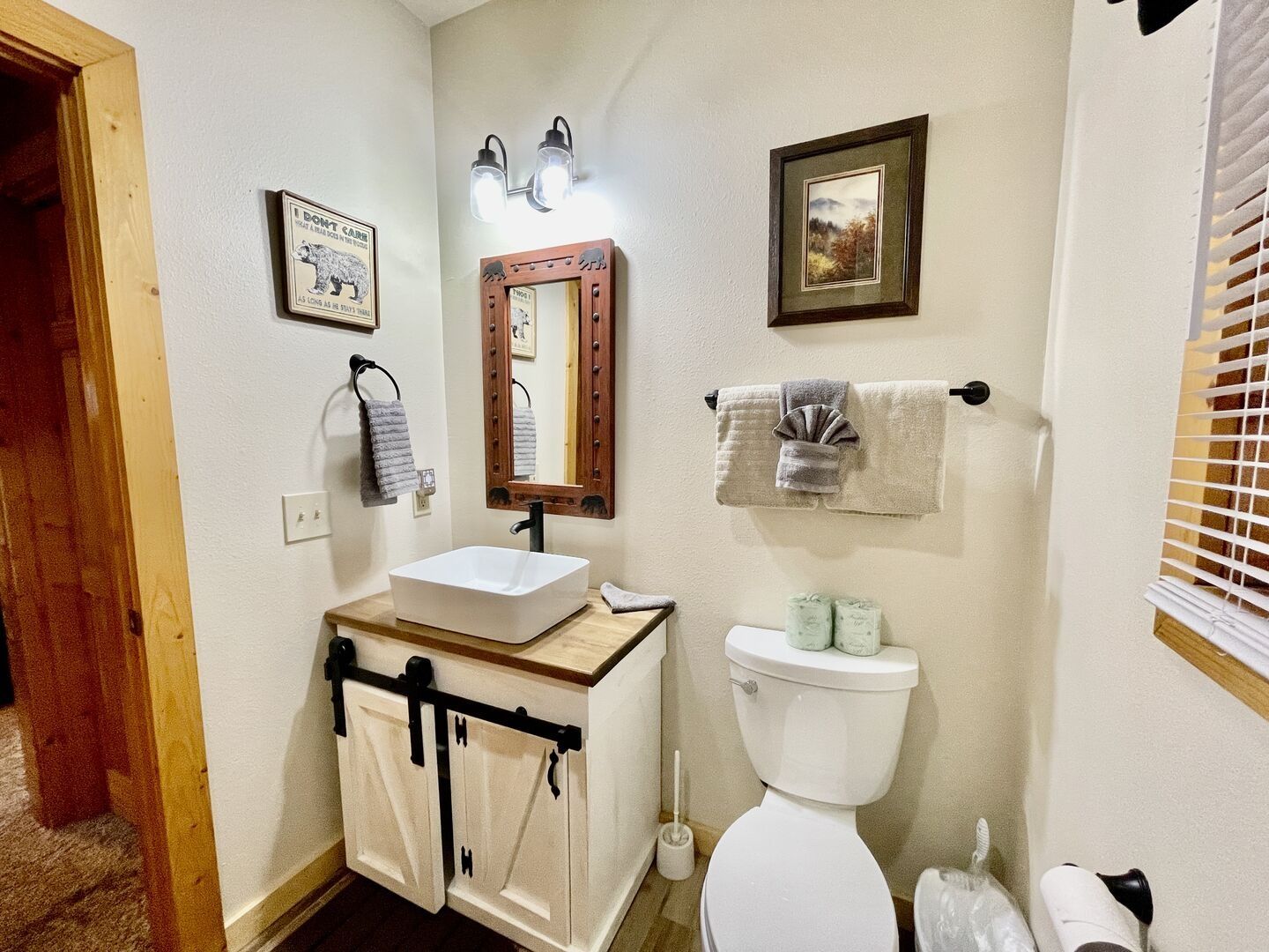 A bathroom with a white sink, a mirror, a toilet, and a towel rack.