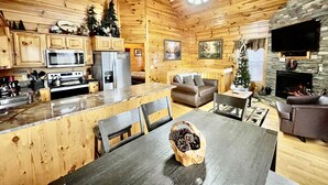 A cozy cabin interior with a kitchen, dining area, and living room. - Picture Perfect 2 Bedroom Cabin by RedAwning (Sevierville)