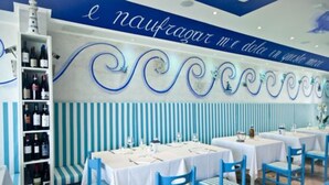 A restaurant interior with striped walls, blue chairs, and tables set for dining. - Marina Beach Suite Hotel (Rimini)