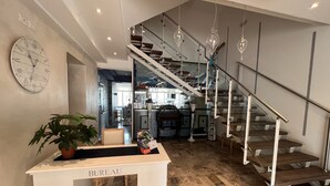 A modern interior with a staircase, a clock, and a reception desk labeled 'BUREAU'. - Marina Beach Suite Hotel (Rimini)