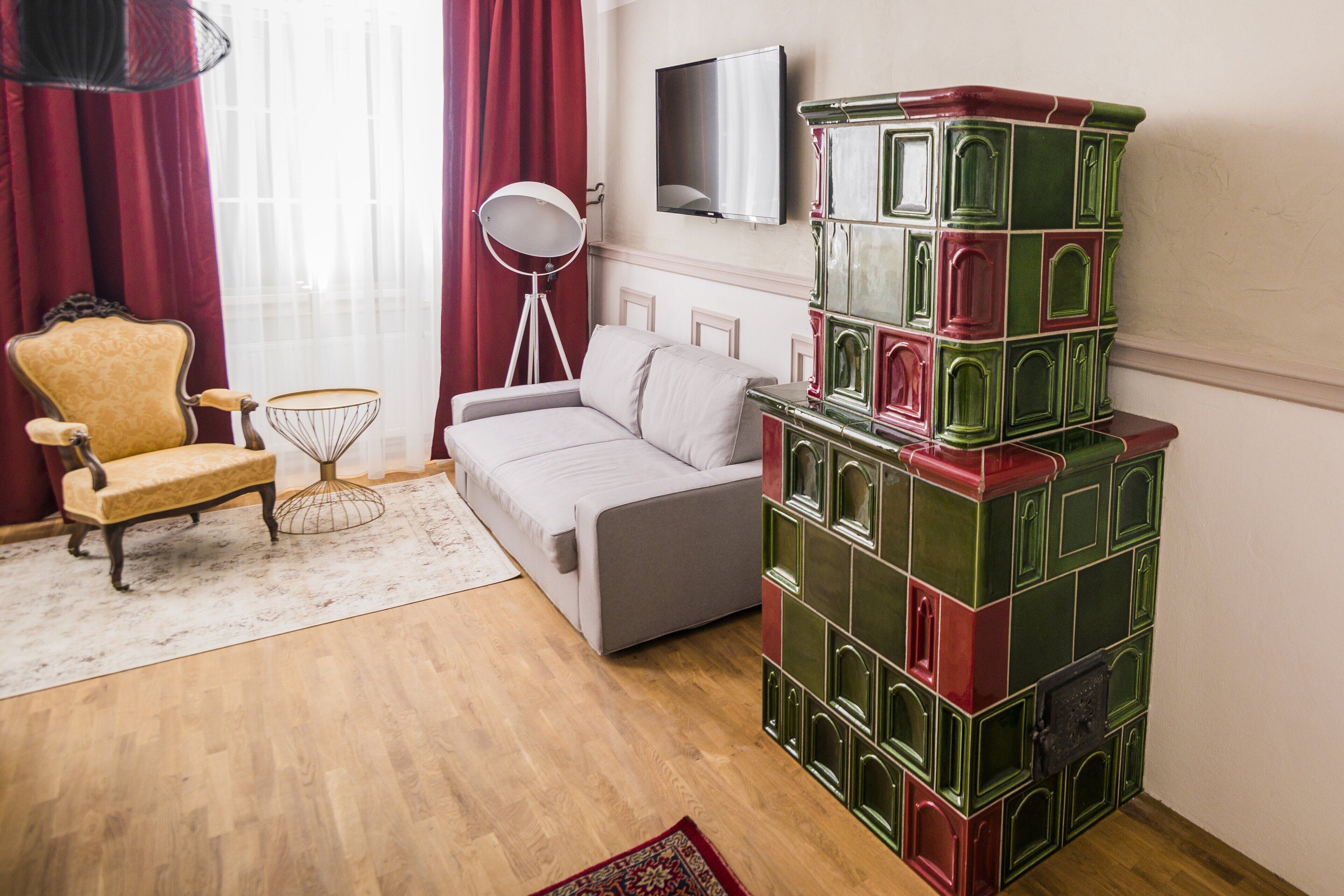 A room with a sofa, a chair, a lamp, and a decorative stack of boxes.