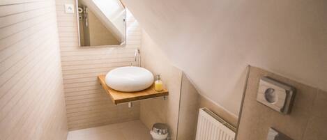 A small, modern bathroom with a toilet, sink, and mirror.