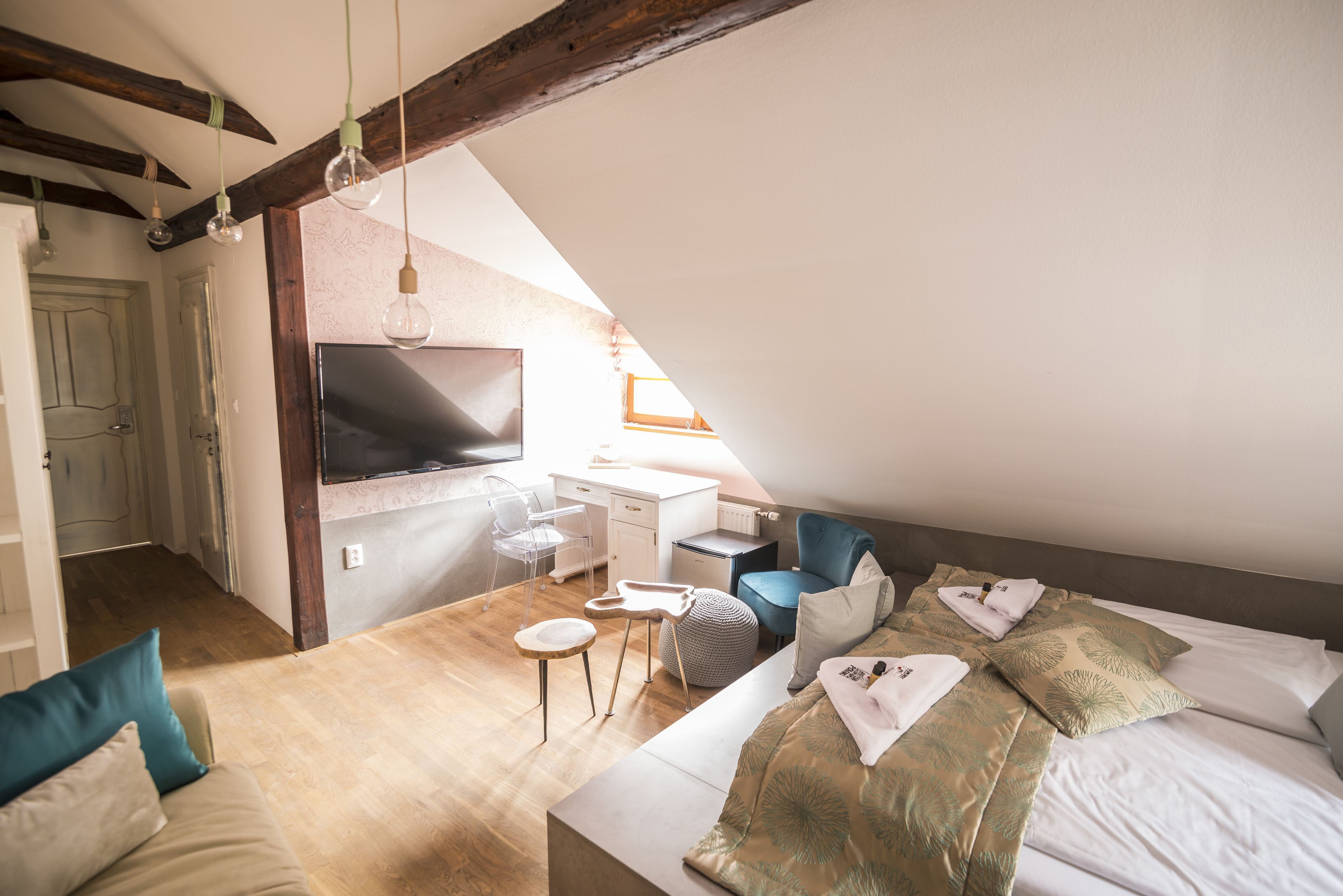 Una habitación moderna y luminosa con una cama, un escritorio y un televisor.
