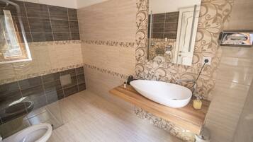 A bathroom with a white sink, a mirror, and a shower.