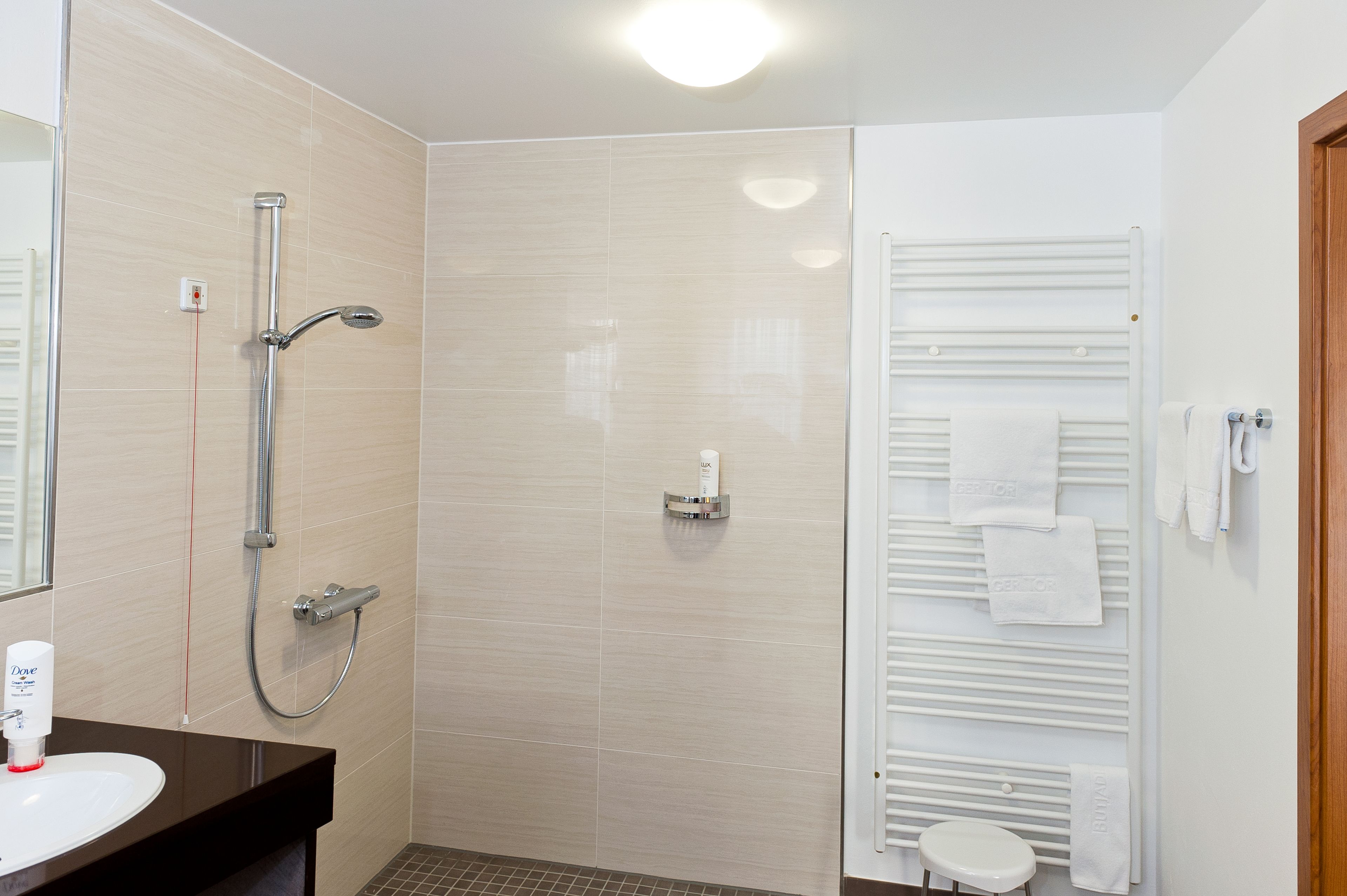 A modern bathroom with a shower, a toilet, and a sink.