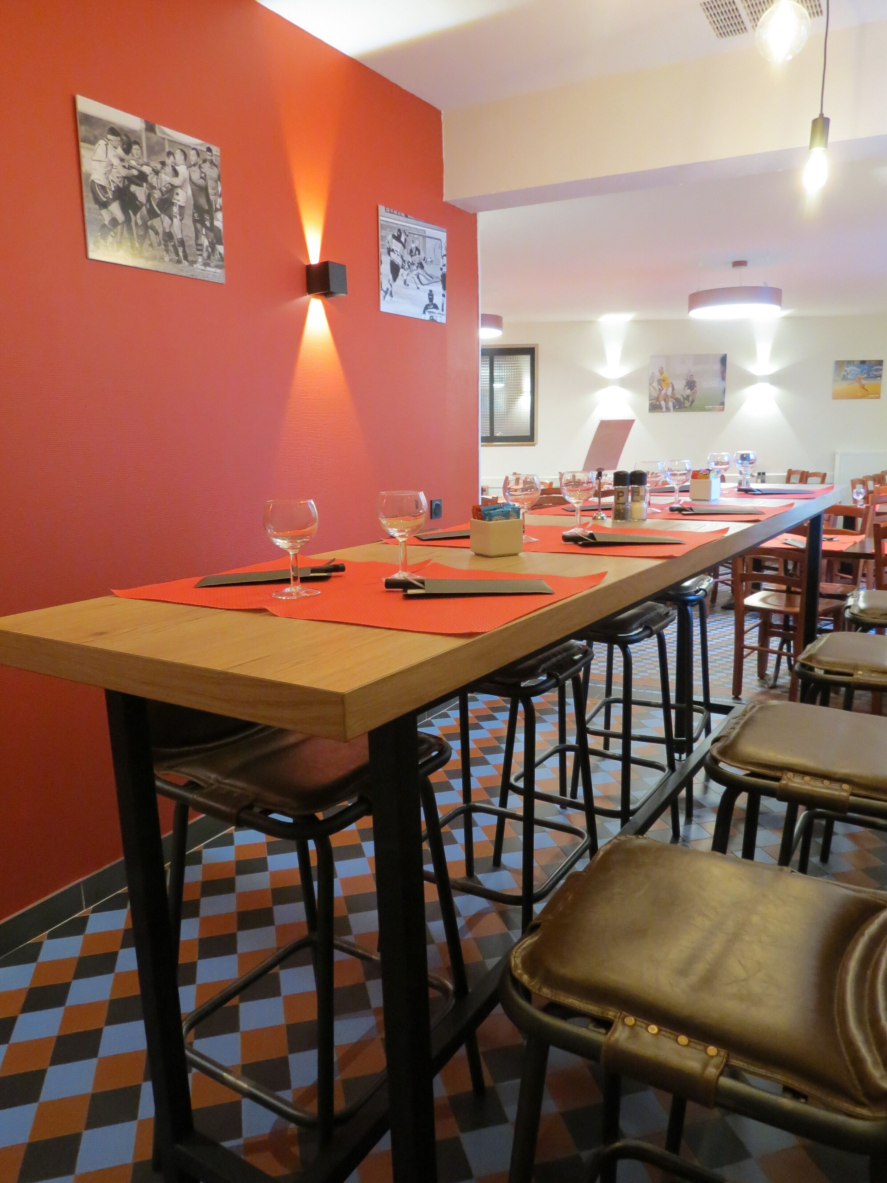 A restaurant with a long table set for dining, multiple chairs, and a checkered floor pattern.