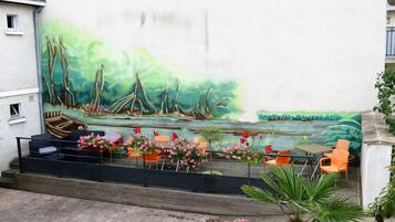 Un mural que muestra un paisaje fluvial con barcos y vegetación en una pared de edificio.