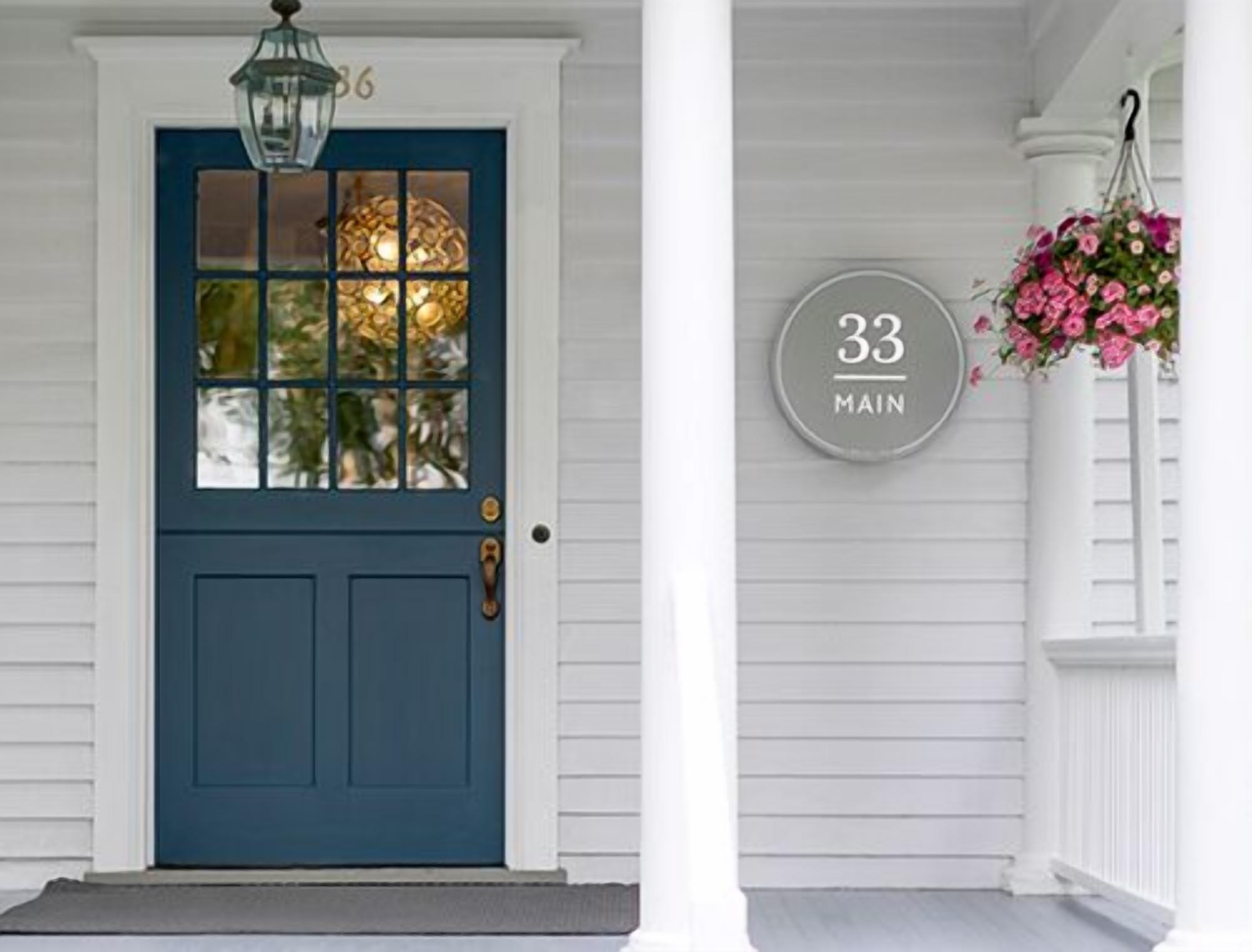 A blue door with a glass panel, a number '33' sign, and a hanging flower basket.