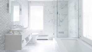 A modern bathroom with a glass shower, white marble walls, and a large window. - 33 Main (Lenox)