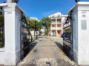 A hotel entrance with a cobblestone pathway leading to a gated driveway. - Hotel Aida (Alassio)