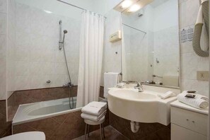 A modern bathroom with a bathtub, shower, sink, and mirror. - Hotel Aida (Alassio)