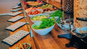 A buffet table with various food items and a coffee machine.