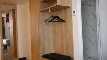 Una habitación con un armario de madera, un banco y una percha para la ropa.