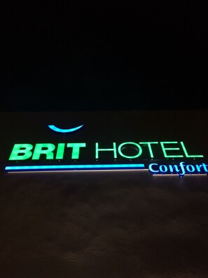 A neon sign for the Brit Hotel with the word "Confort" visible. - Brit Hotel Confort Loches (Loches)
