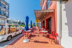 En restaurang med en uteservering, en golfbil och en byggnad med en skylt.