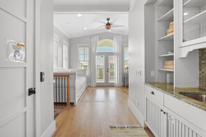 A hallway with a wooden floor, white walls, and a ceiling fan. - Pompano Palace - 4 Br home by RedAwning (Panama City Beach)