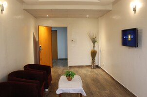 Habitación Deluxe | Sala de estar | Una televisión de pantalla plana