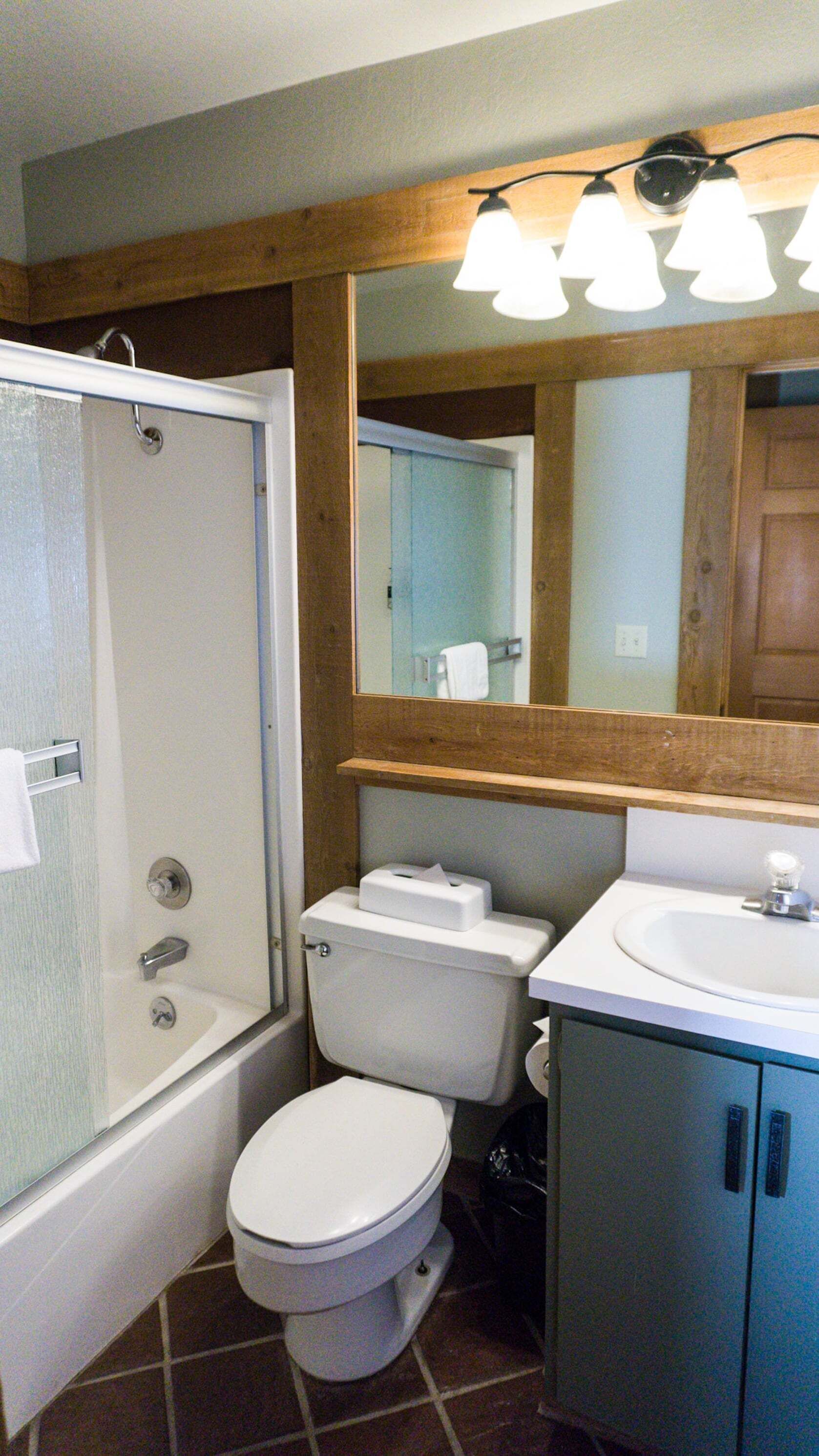 A bathroom with a shower, toilet, and sink.