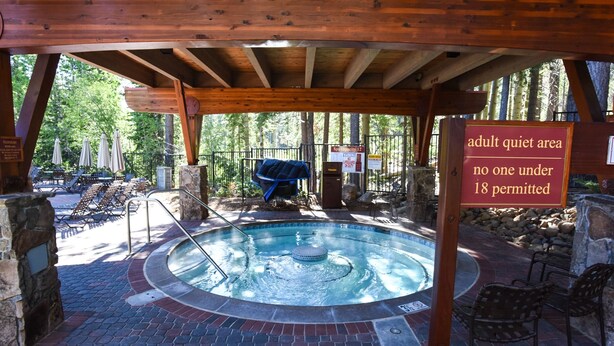 An outdoor hot tub area with a sign indicating it is an adult quiet area with no one under 18 permitted. - Ski Trails 4024 (Truckee)