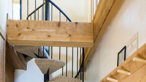 A spiral staircase with a wooden finish and a cat tree attached to the wall. - Ski Trails 4024 (Truckee)