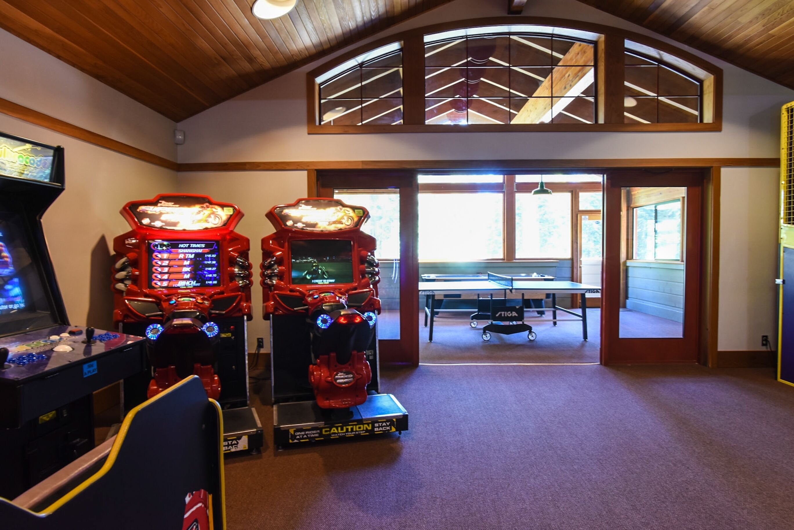 Ein Raum mit Spielautomaten, einem Tischtennis-Tisch und Blick ins Freie.