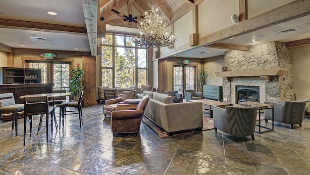A spacious lobby with a stone fireplace, comfortable seating, and large windows. - Refined  With Sunny Views 2 Blocks To Downtown Breck 1 Bedroom Condo by RedAwning (Breckenridge)