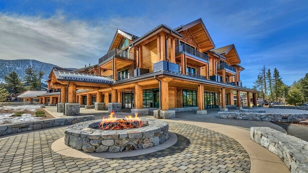 A large, multi-story lodge with a stone fire pit in the center. - LuxuryÂ 2br  Steps From Heavenly Village & Gondola 2 Bedroom Condo by RedAwning (South Lake Tahoe)