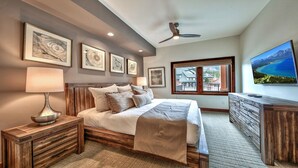A bedroom with a bed, bedside tables, a dresser, a ceiling fan, and framed artwork on the wall. - LuxuryÂ 2br  Steps From Heavenly Village & Gondola 2 Bedroom Condo by RedAwning (South Lake Tahoe)