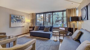 A modern hotel room with a large window, a sofa, a small table, and a lamp. - Winter Ski-in/out Studio Sleeps 4, Steps To Historic Main St Studio Bedroom Condo by RedAwning (Breckenridge)